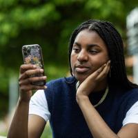 Ung kvinde kigger på sin telefon