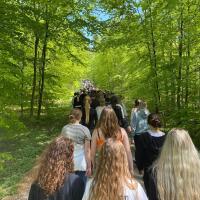 En flod af elever går gennem skoven